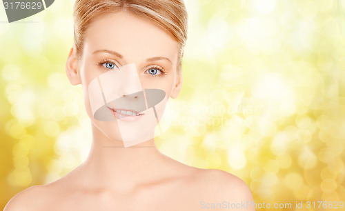 Image of beautiful young woman face over yellow background