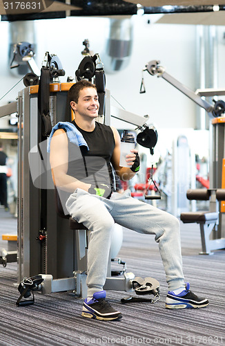 Image of smiling man exercising on gym machine