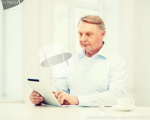 Image of old man with tablet pc computer at home