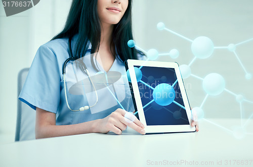 Image of close up of doctor showing molecules on tablet pc