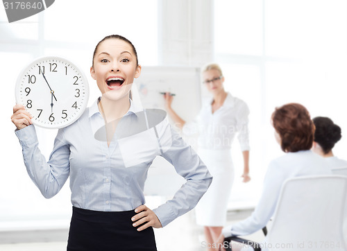 Image of attractive businesswoman with wall clock