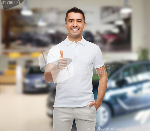 Image of man showing thumbs up over auto show background