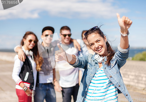 Image of teenage girl with headphones and friends outside