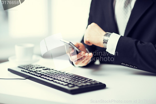 Image of man hands with keyboard, smartphone and wristwatch