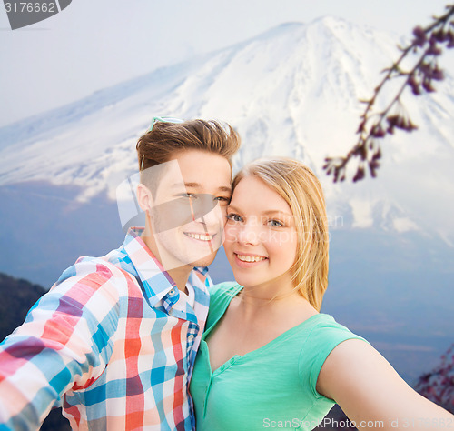 Image of smiling couple with smartphone in city