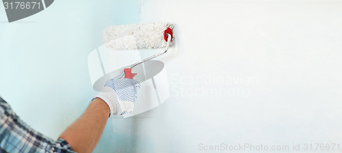 Image of close up of male in gloves painting wall