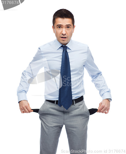 Image of surprised businessman showing empty pockets