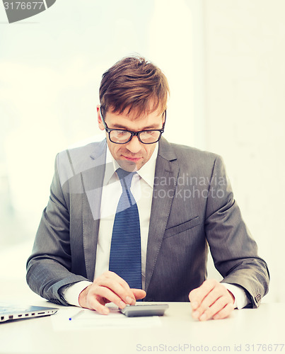 Image of businessman with papers and calculator