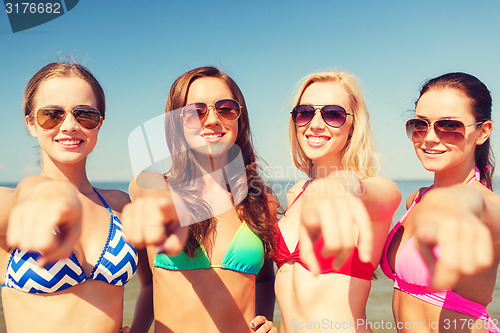 Image of group of smiling young women on beach