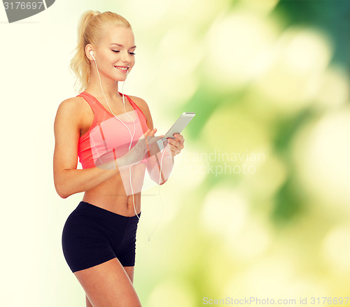 Image of smiling sporty woman with smartphone and earphones