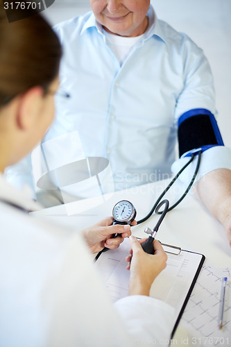 Image of close up of doctor measuring blood pressure