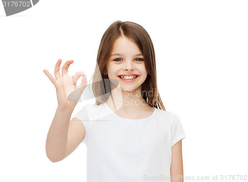 Image of little girl in white t-shirt showing ok gesture