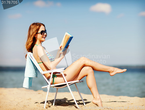 Image of girl reading book on the beach chair