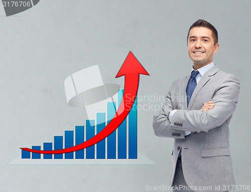 Image of happy businessman in suit with growth chart