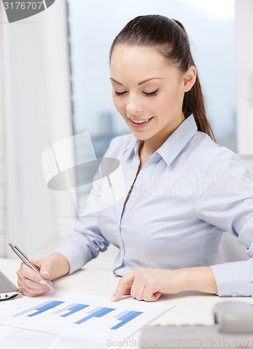 Image of businesswoman with phone, laptop and files