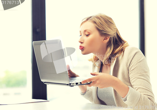 Image of woman with computer kissing the screen