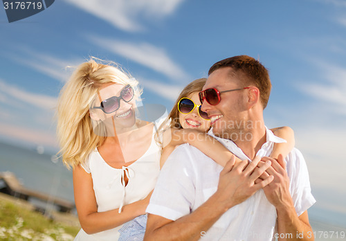 Image of happy family in sunglasses having fun outdoors