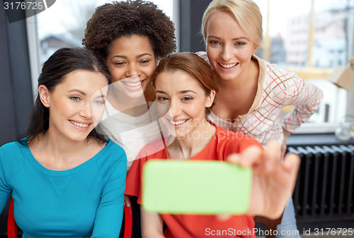Image of happy young women taking selfie with smartphone