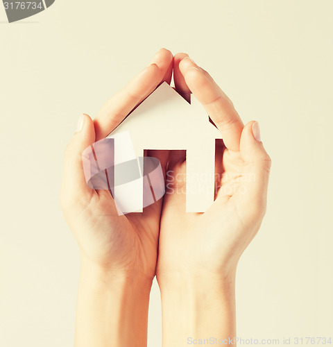 Image of woman hands with paper house