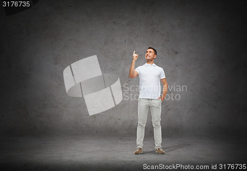Image of smiling man pointing finger up