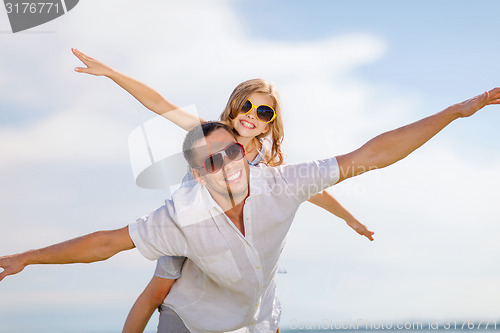 Image of happy father and child in sunglasses over blue sky