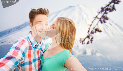 Image of smiling couple with smartphone in city