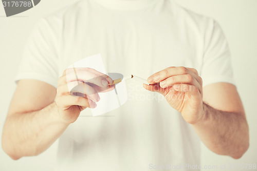 Image of man breaking the cigarette with hands