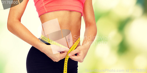 Image of close up of female hands measuring waist