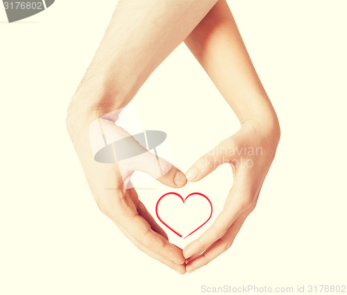 Image of woman and man hands showing heart shape