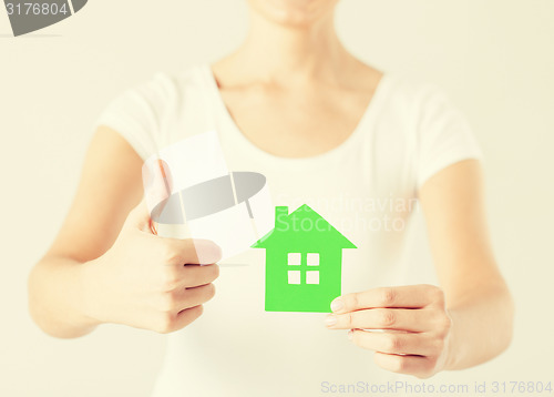 Image of woman hands holding green house