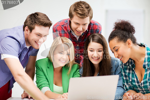 Image of international students looking at laptop at school