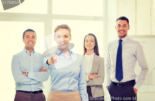 Image of businesswoman in office pointing finger at you