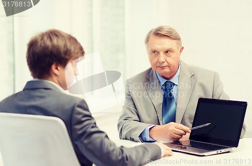 Image of older man and young man with laptop computer