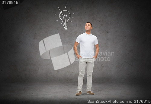 Image of smiling man looking up to lighting bulb doodle