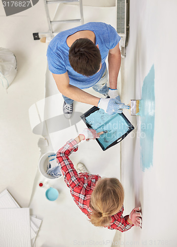 Image of close up of couple painting wall at home