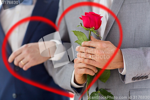 Image of close up of happy male gay couple holding hands