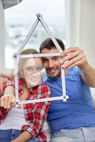 Image of close up of couple with house shape ruler