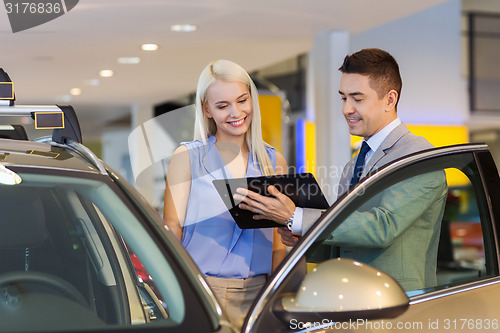 Image of happy woman with car dealer in auto show or salon