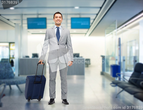 Image of happy businessman in suit with travel bag