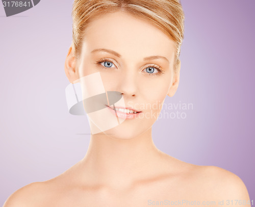 Image of beautiful young woman face over violet background