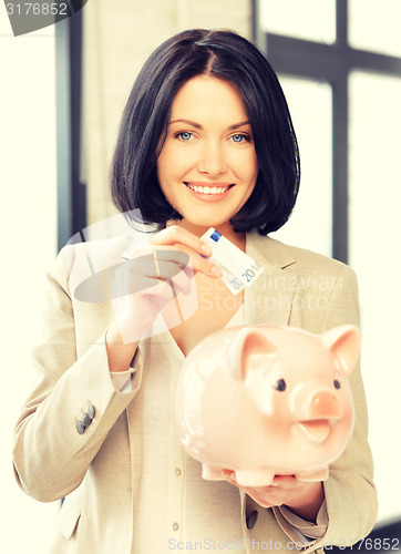 Image of lovely woman with piggy bank and money