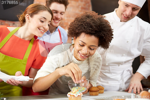 Image of happy friends and chef cook baking in kitchen