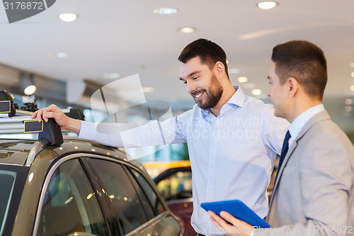 Image of happy man with car dealer in auto show or salon