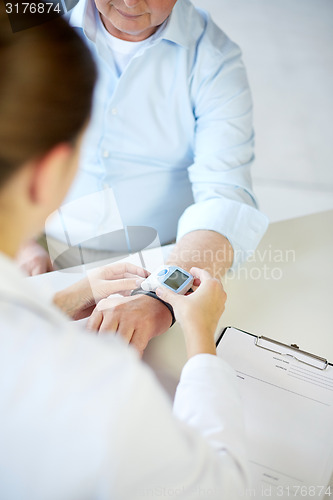 Image of close up of doctor measuring pulse to senior man