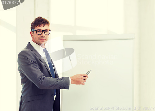 Image of businessman pointing to flip board in office