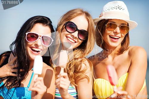 Image of girls in bikinis with ice cream on the beach
