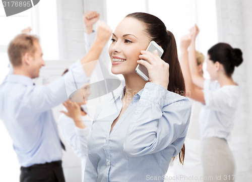 Image of young smiling businesswoman with smartphone