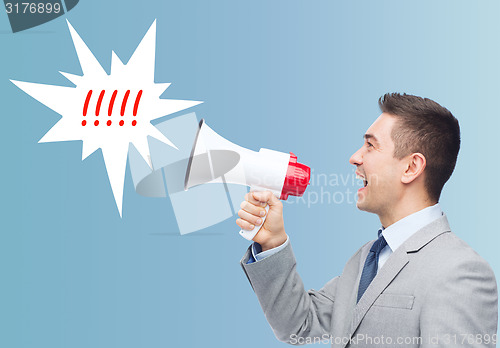 Image of happy businessman in suit speaking to megaphone