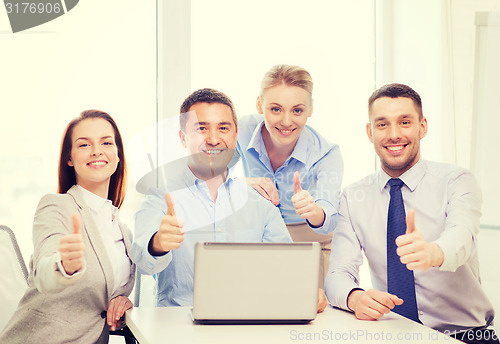Image of business team working with laptop in office