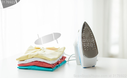 Image of close up of iron and clothes on table at home